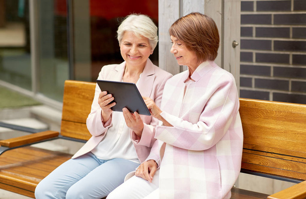 senior women with tablet computer in city - Foto, afbeelding