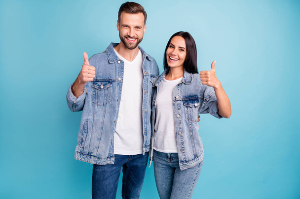 Portrait of pretty sweethearts hugging embracing smiling wearing denim jeans isolated over blue background - Foto, Imagem