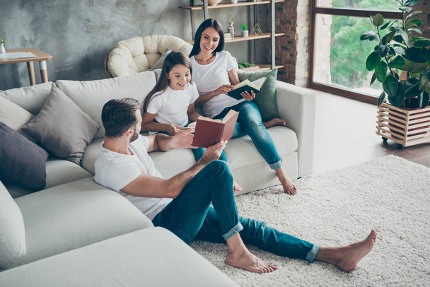 Nice attractive charming friendly adorable cheerful idyllic glad brunette family schoolgirl wearing casual white t-shirts jeans spending free time at industrial loft style interior living-room indoor - Фото, изображение