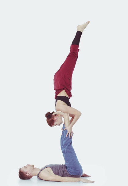 Young athletic couple practicing acroyoga. Balancing in pair. - Photo, image