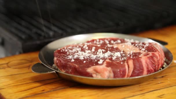steak.beef is sprinkled with coarse salt and pepper and sent to the grill.close-up. - Video