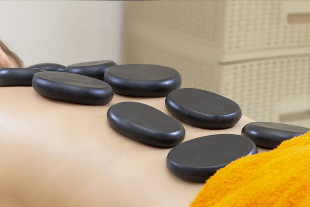 Spa Hot Stone Massage. Stone treatment. Woman getting a hot stone massage at a day spa. beautiful girl - Foto, immagini
