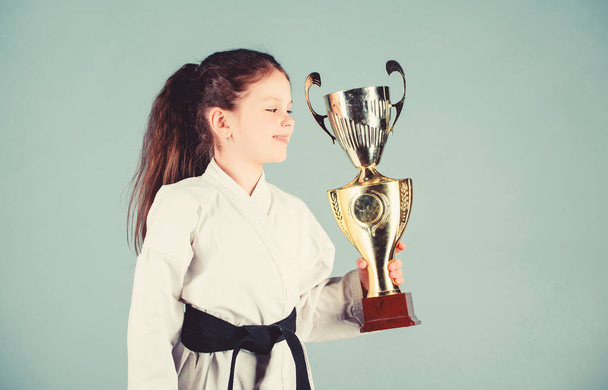 Strong and confident kid. Girl little child in white kimono with belt. Karate fighter child. Karate sport concept. Self defence skills. Karate gives feeling of confidence. Celebrate achievement - Photo, image