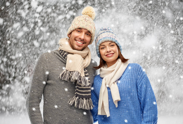 happy couple in winter clothes over snow - Valokuva, kuva