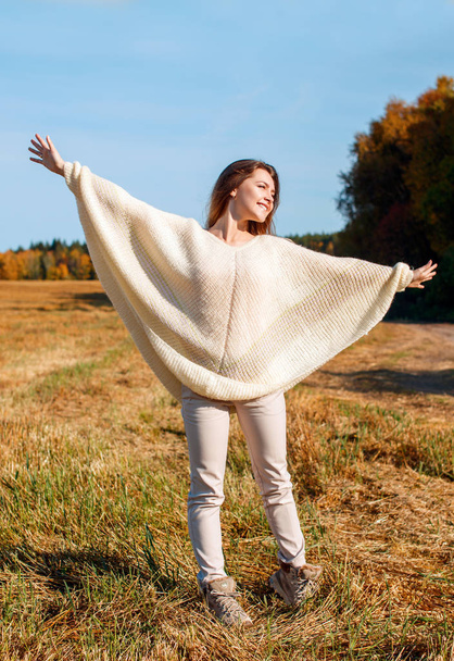 Веселая девушка с поднятыми руками на поле в теплый осенний сезон
. - Фото, изображение