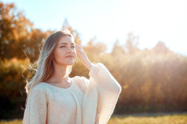 Chica bonita posando en la cámara y disfrutando de un día soleado de otoño
. - Foto, imagen