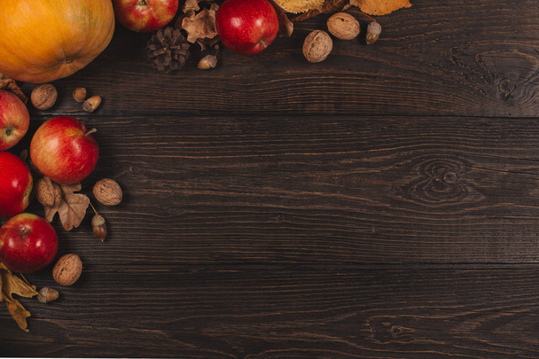 Autumn background with pumpkin, apples and nuts. Dark rustic wooden background.  - Fotó, kép