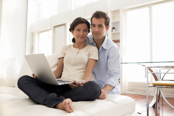 Cheerful Couple Using Laptop Together At Home - Foto, imagen