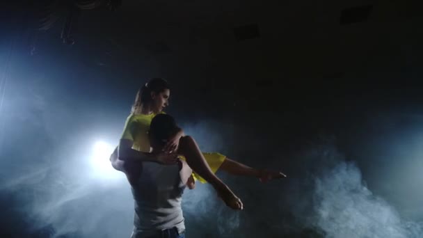 пара танцующих на сцене в прожекторах и дыму
 - Кадры, видео