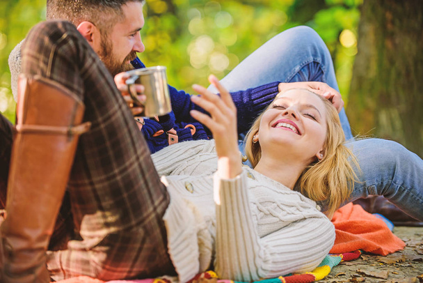 Cheerful couple. couple in love relax in autumn forest with tea or coffee. camping and hiking. happy woman and bearded man drink mulled wine. love date and romance. Family picnic. Valentines day - 写真・画像