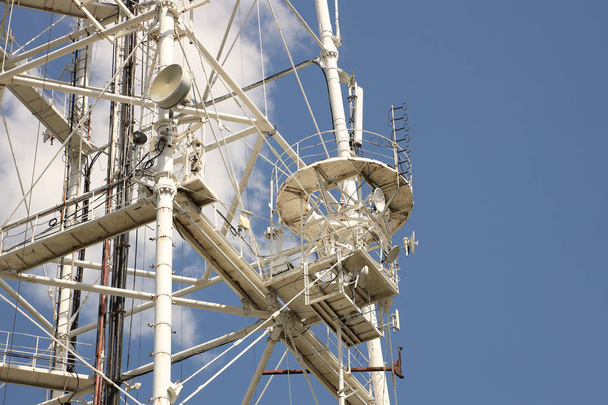 Радіо-телевізійна вежа для прийому і передачі електромагнітних сигналів на відстань. Металочерепиця високотехнологічної конструкції оповита білою хмарою. Джерело частоти пульсу. Львів, Україна - Фото, зображення