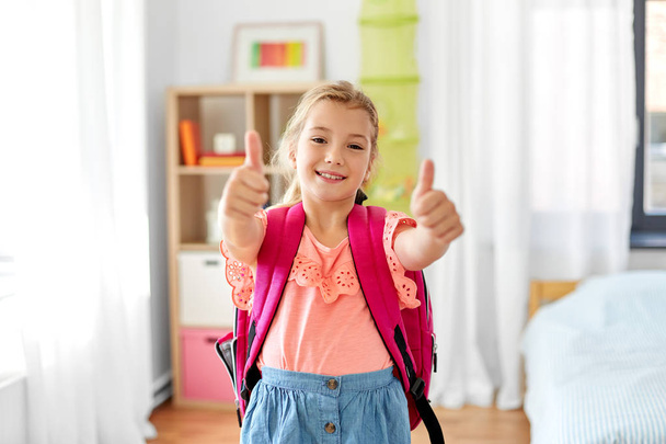 студентка со школьной сумкой показывает большие пальцы вверх - Фото, изображение