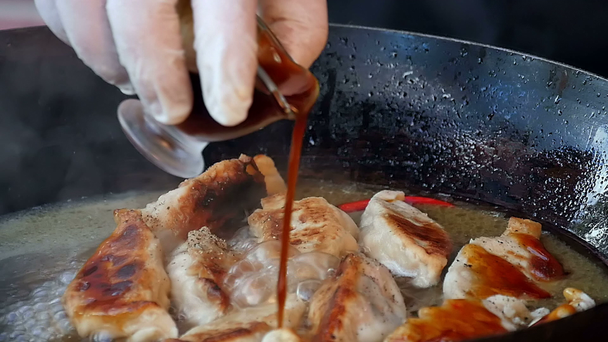 Наливание соуса на жареные пельмени в кастрюле
 - Кадры, видео