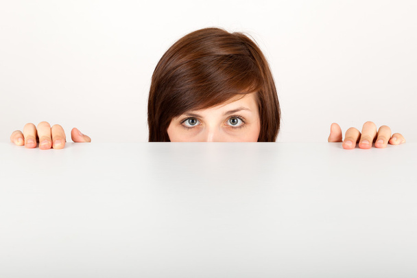 Молода жінка ховає тривогу за столом
 - Фото, зображення