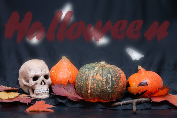 skull, halloween pumpkins, jack's head and autumn leaves on a black background, preparation for the baby cherry, still life, celebrate October 31 - Foto, imagen