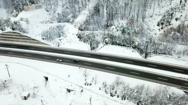 Es invierno en una autopista en Eslovenia. El paisaje se ve hermoso porque está cubierto de nieve. Disparo aéreo
. - Metraje, vídeo