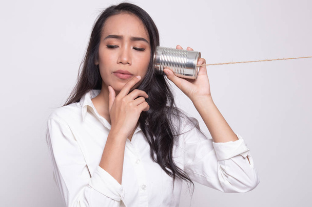 Young Asian woman hearing with tin can phone and thinking. - Φωτογραφία, εικόνα