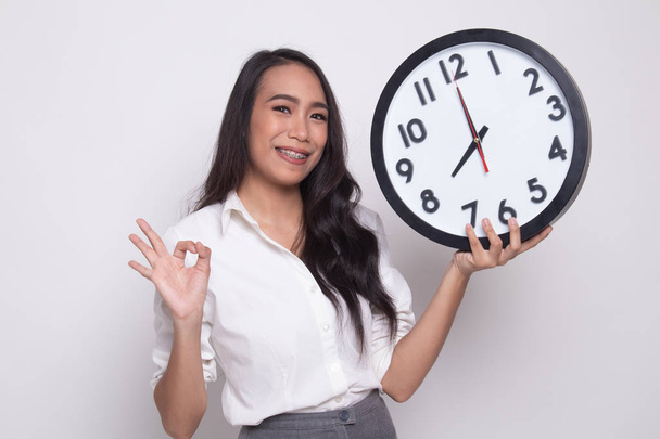Young Asian woman show OK with a clock. - Фото, зображення