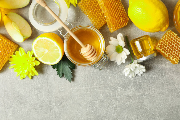 Flat lay with honey, flowers and fruits on grey background, copy - Photo, Image