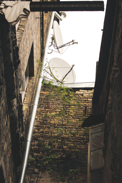 Две спутниковые антенны на крыше старого здания
 - Фото, изображение