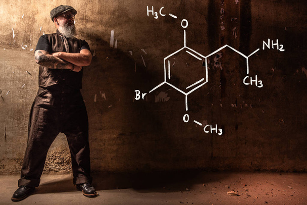 Brodaty Starzec prezentujący wzór chemiczny Dimethoxybromoamfetamine dob - Zdjęcie, obraz