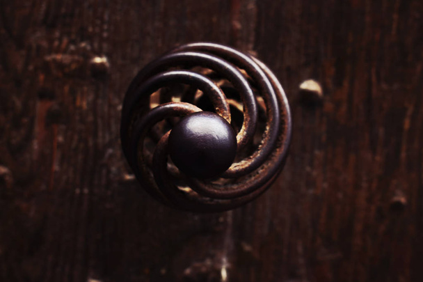Old spiral door iron metal handle to a haunted house close up - Foto, afbeelding