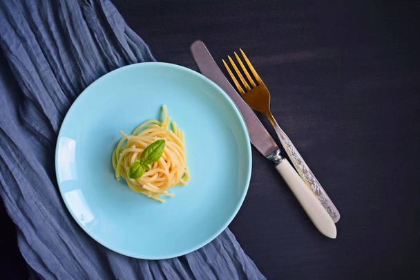 Delicious spaghetti with greens on a black background. - Photo, image