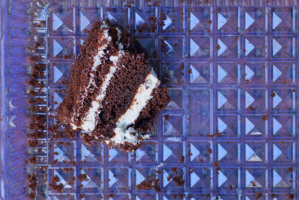 шматок коричневого торта лежить у сірій пластиковій коробці
 - Фото, зображення