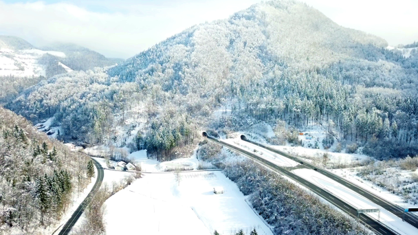 Bellissima natura in inverno. C'è un'autostrada e i veicoli stanno guidando su di essa. Le foreste sono bianche a causa della neve
. - Filmati, video