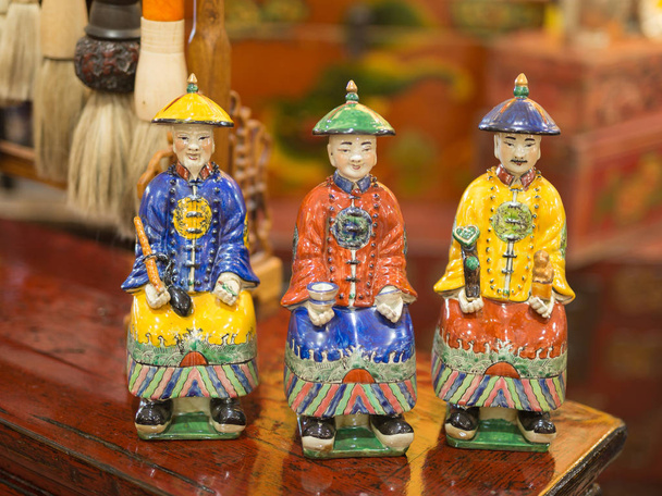 Aziatische beeldje van keramiek: drie mannen met typische kleding en hoeden - Foto, afbeelding