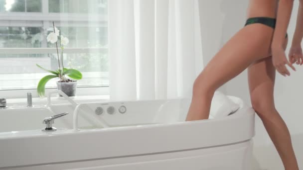 Impresionante mujer sexy entrar en bañera de hidromasaje en el centro de spa
 - Metraje, vídeo