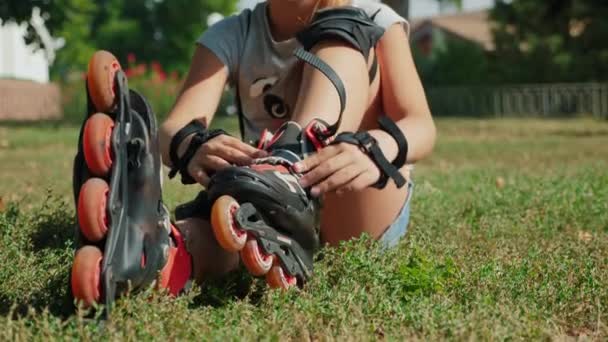 Girl putting on her rollerblades, close-up - Footage, Video