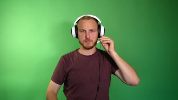 Brodatego mężczyznę konfiguruje mikrofon w słuchawkach i zaczyna grę na Consol - Materiał filmowy, wideo