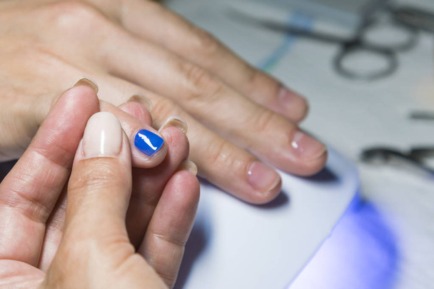 Processo di manicure, smalto blu applicando
. - Foto, immagini