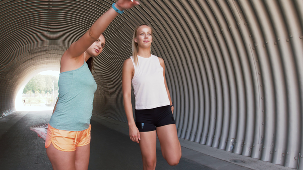 mujeres con rastreadores de fitness que se extienden al aire libre
 - Metraje, vídeo