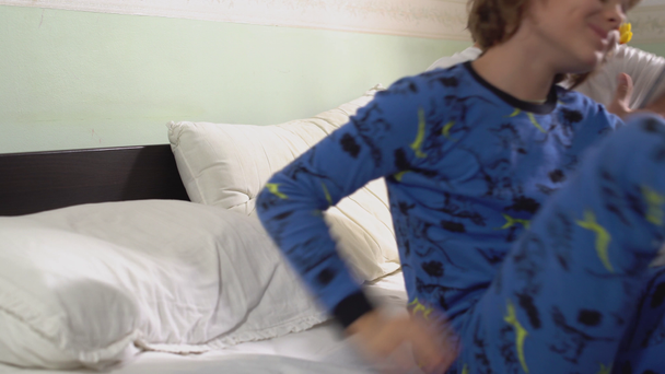 Two brothers lie down in bed covered with white blanket in the morning and then get up from the bed. - Metraje, vídeo