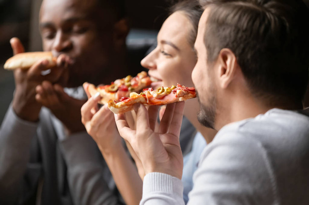 Close up happy diverse friends eating pizza in cafe together - 写真・画像