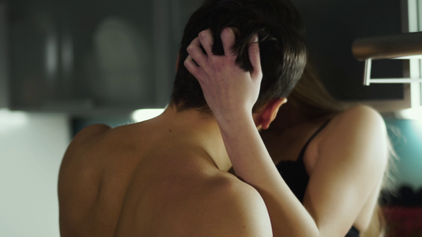 heißes junges Paar küsst leidenschaftlich in der Küche, das Mädchen berührt Kerls Haare, und der Kerl küsst sie im Nacken - Filmmaterial, Video