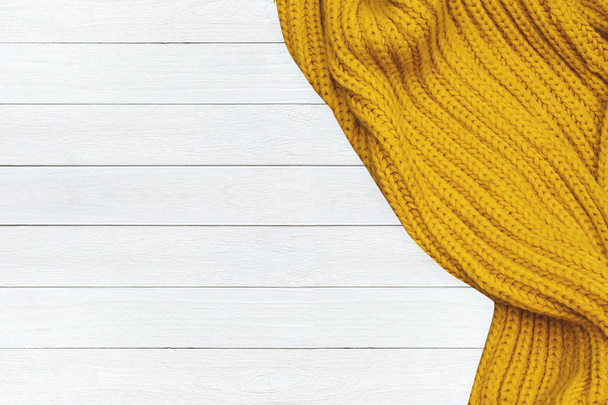 color mustard woolen winter scarf isolated on wooden background - Valokuva, kuva