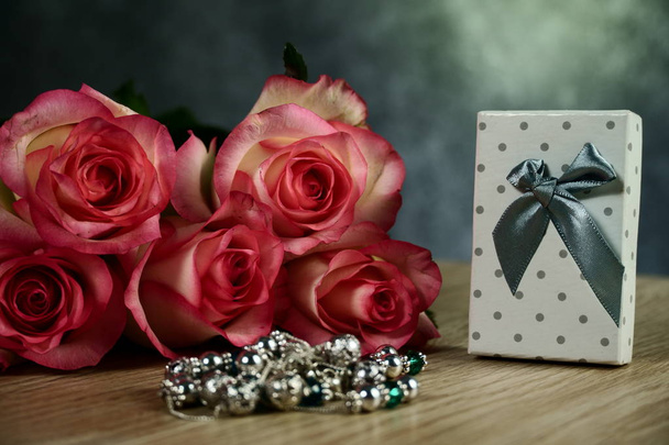 τριαντάφυλλα Dolce Vita με διακεκομμένο λευκό παρόν κουτί σε φόντο ξύλου - Φωτογραφία, εικόνα