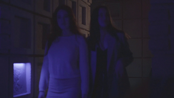 Modern gece kulübünde koridorda yavaşça yürüyen iki güzel kadın. Kız arkadaşlar birlikte takılacaklar. Parti zamanı - Video, Çekim