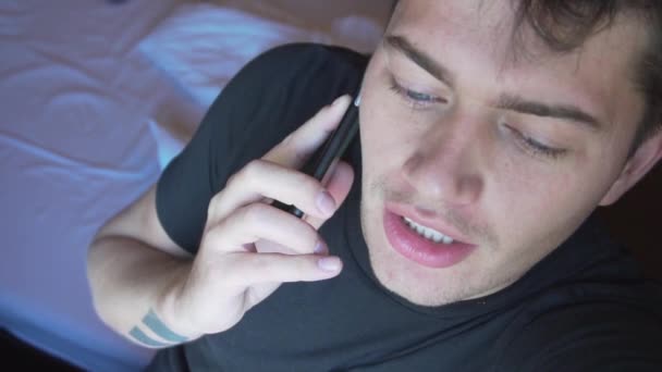 Face of cute caucasian man in dark t-shirt and blue eyes, speaking on smartphone - Filmagem, Vídeo