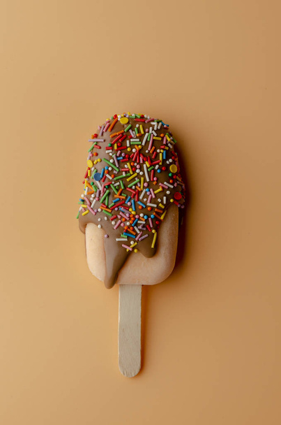 Апельсиновое мороженое с шоколадной глазурью на светлом персиковом фоне
. - Фото, изображение