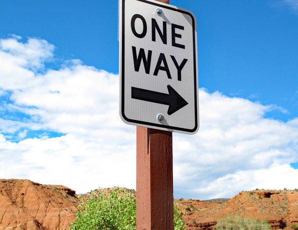 One Way straat teken op een kleine Desert Road met rode rots en blauwe hemel - Foto, afbeelding