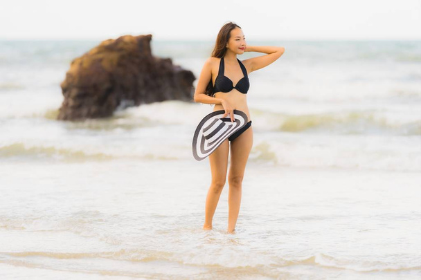 Retrato hermosa joven mujer asiática usar bikini en la playa se
 - Foto, imagen