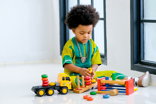 African young boy has fun with playing various type of toys. - Foto, afbeelding