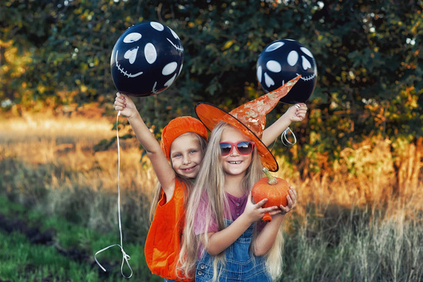 Divertenti amici ragazza su Halloween con zucca e palle. Vacanza allegra
 - Foto, immagini