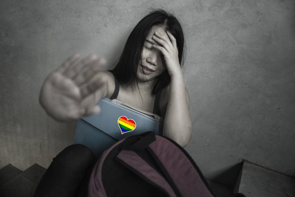 respect for homosexual and anti sexual discrimination campaign. Young beautiful depressed and scared Asian student woman with gay flag on her backpack - Foto, Bild