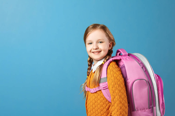 Portrait of a little girl schoolgirl with a backpack on a blue background. Back to school. The concept of education. - Fotografie, Obrázek