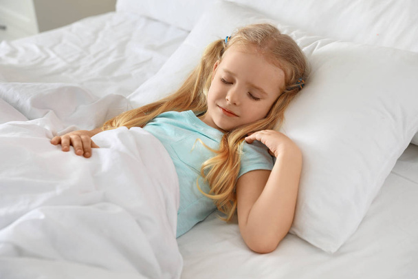 Portrait of cute little girl sleeping in large bed - Фото, изображение